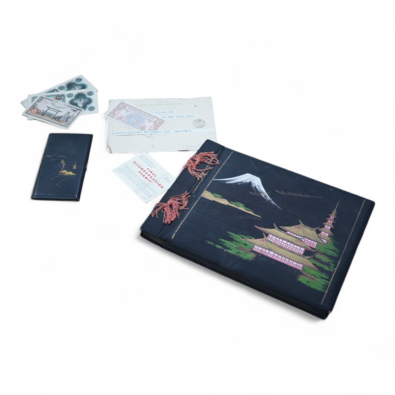 A Japanese photograph album, late 1940's to include banknotes and a telegram, together with a cigarette case